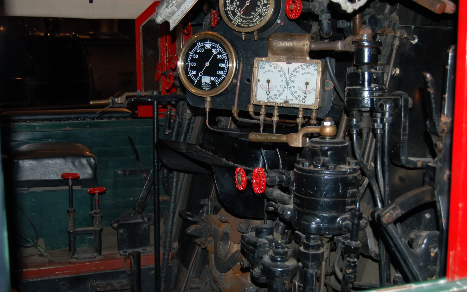 Interior view of a historic steam locomotive cab at the California State Railroad Museum showing engineering controls and seating